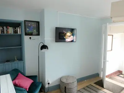a living room with a blue wall with a couch at Ivybank Cottage in Lamlash
