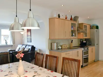 a kitchen and living room with a table and chairs at Lia Fail in Ballachulish