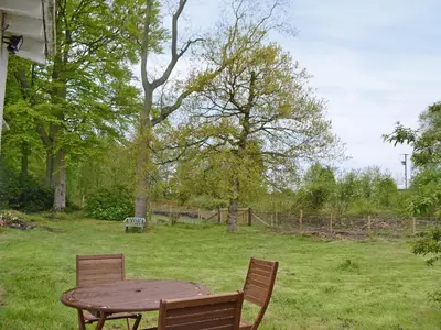 a wooden table and two chairs in a field at Fernwoodlea in Blairhall