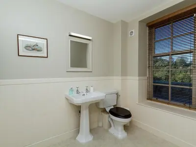 a white bathroom with a toilet and a sink at Two The Stables in Dalrymple