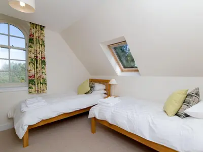 two beds in a room with a window at One The Stables in Dalrymple