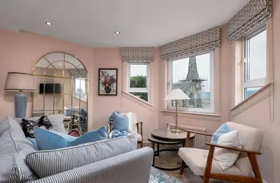 a living room with a couch and chairs and the eiffel tower at Munro Guest House in Stirling