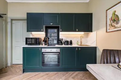 a kitchen with green cabinets and an oven at Munro Guest House in Stirling
