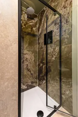 a shower with a glass door in a bathroom at Munro Guest House in Stirling