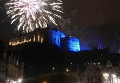 a castle with fireworks in the sky behind it at Castle Suite 1 Old Town in Edinburgh