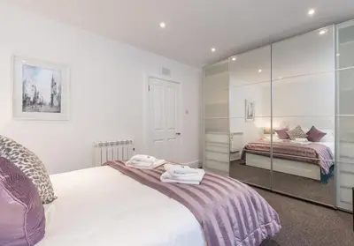 a bedroom with a bed and a mirror at Castle Suite 1 Old Town in Edinburgh