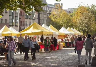 a group of people walking around a market with tents at Castle Suite 3 Old Town in Edinburgh