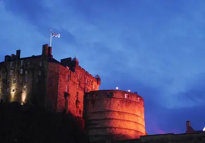 a castle with a flag on top of it at Castle Suite 3 Old Town in Edinburgh