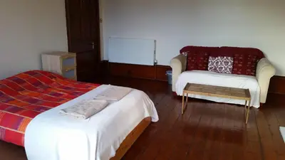 a bedroom with a bed and a couch and a chair at Broompark House in Glasgow