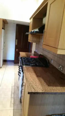 a kitchen with a stove and a counter top at Broompark House in Glasgow