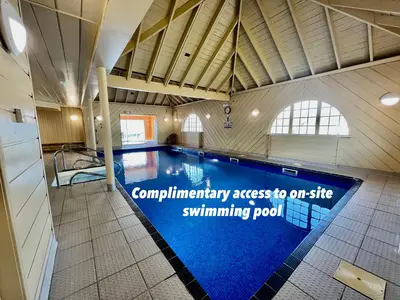 a swimming pool in a building with a sign that reads compliance access to our site at Loch Linnhe Waterfront Lodges with Hot Tubs in Glencoe