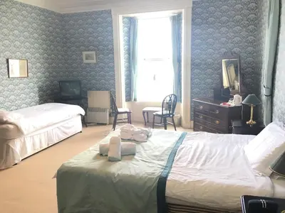 a bedroom with two beds with towels on the bed at Cannon House Guest House in Rothesay