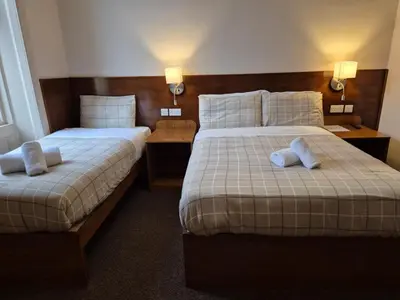 a hotel room with two beds and two lamps at Douglas Hotel in Glasgow