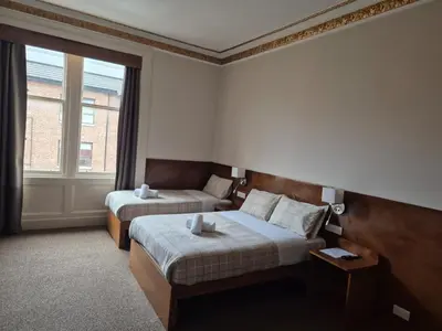 a hotel room with two beds and a window at Douglas Hotel in Glasgow