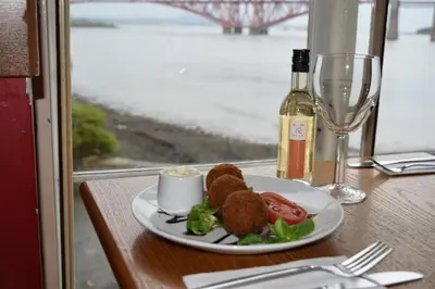 a plate of food on a table with a bottle of wine at The Stag Head Hotel in Edinburgh