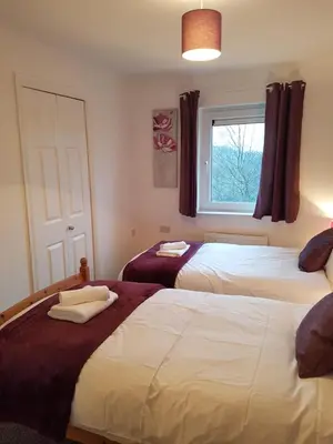 a bedroom with two beds and a window at Bathgate Contractor and Business Apartment in Bathgate