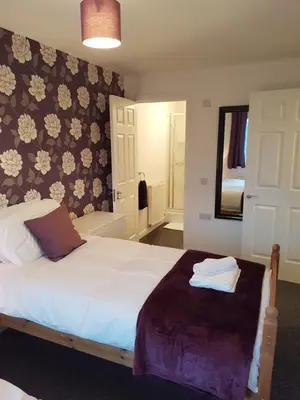 a bedroom with a white bed and a mirror at Bathgate Contractor and Business Apartment in Bathgate