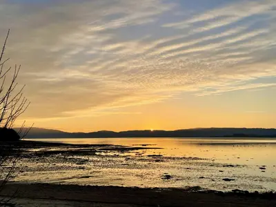 a sunset over a body of water at Cockleshell Lodge in Otter Ferry