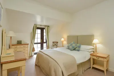 a bedroom with a large white bed and a dresser at Melfort Village in Oban