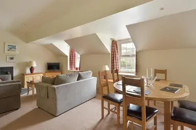 a living room with a couch and a table at Melfort Village in Oban