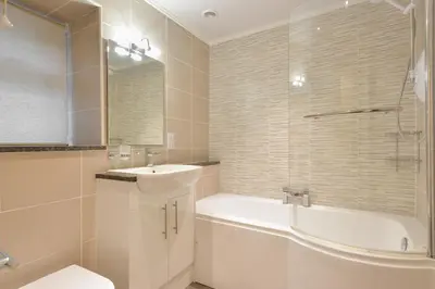 a bathroom with a tub and a sink and a toilet at Melfort Village in Oban