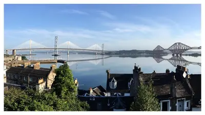 a large bridge over a river with buildings and a bridge at Forth Reflections Self Catering in Queensferry