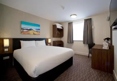 a hotel room with a large bed and a desk at Chain Runner, Livingston by Marston's Inns in Livingston