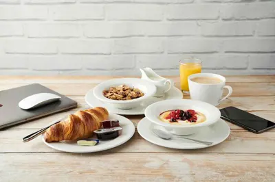 a table with two plates of breakfast food and a laptop at Chain Runner, Livingston by Marston's Inns in Livingston