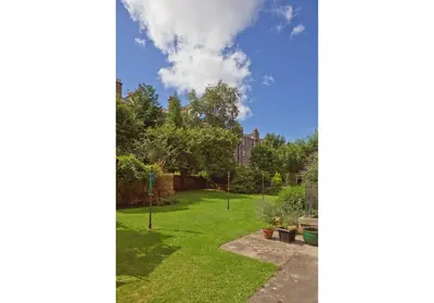 a garden with grass and trees and a blue sky at The Edinburgh Address - Classic Marchmont Charm in Edinburgh