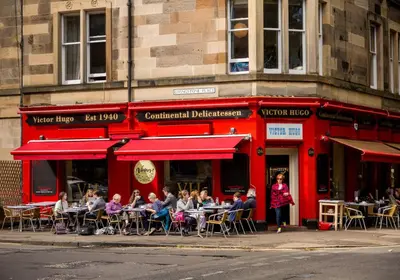 a group of people sitting at tables outside a restaurant at The Edinburgh Address - Classic Marchmont Charm in Edinburgh