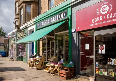 a store with a green awning on a street at The Edinburgh Address - Classic Marchmont Charm in Edinburgh