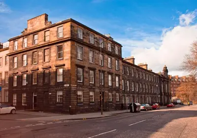 a large brick building on the side of a street at Edinburgh Castle Suite - The Edinburgh Address in Edinburgh