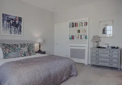 a bedroom with a bed and a dresser with a book shelf at The Skyline - The Edinburgh Address in Edinburgh