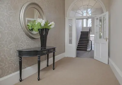 a vase of flowers on a table in a hallway at The Skyline - The Edinburgh Address in Edinburgh