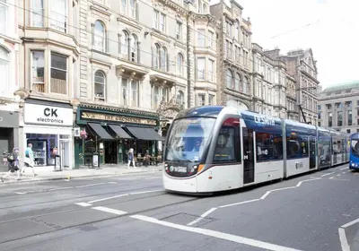 a bus is driving down a city street at The Skyline - The Edinburgh Address in Edinburgh