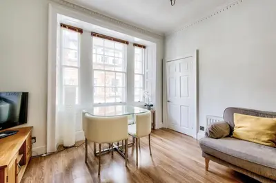 a living room with a glass table and a couch at Rose Street - Watchmakers Apartment in Edinburgh