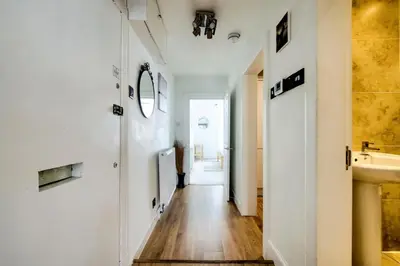 a hallway with white walls and a wooden floor at Rose Street - Watchmakers Apartment in Edinburgh