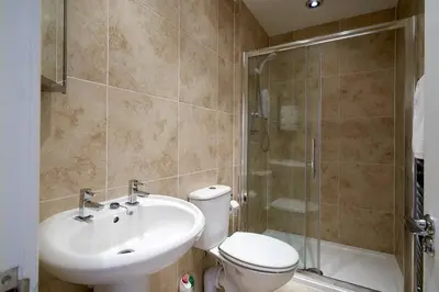 a bathroom with a toilet and a sink and a shower at Rose Street - Watchmakers Apartment in Edinburgh
