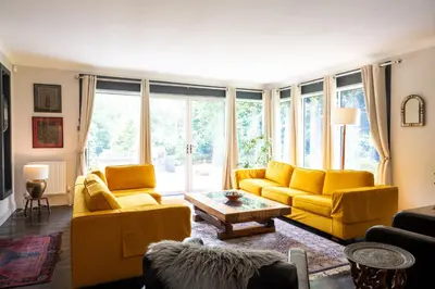 a living room with yellow furniture and a large window at Strathendrick House Magnificent property with Garden in Drymen