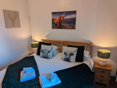 a bedroom with two beds with blue towels on them at Brig O'Doon Guest House in Edinburgh