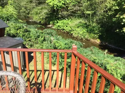 a view of a river from a wooden deck at Rannoch Lodge in Auchterarder