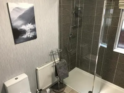 a bathroom with a toilet and a glass shower at Rannoch Lodge in Auchterarder