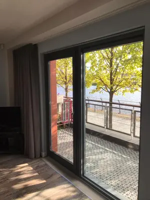 a room with a sliding glass door with a view of the street at Riverside West End Apartment in Glasgow