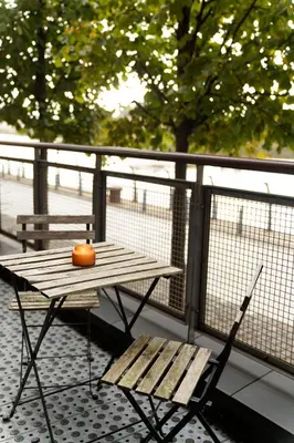a wooden table and a bench on a balcony at Riverside West End Apartment in Glasgow
