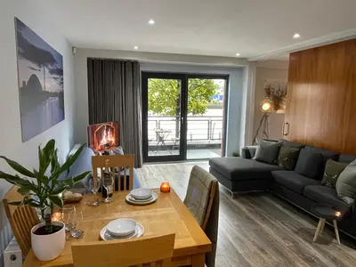 a living room with a table and a living room with a couch at Riverside West End Apartment in Glasgow