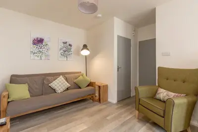 a living room with a couch and a chair at The Wee Thistle in Edinburgh