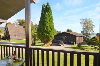 a view of a house from a porch with a tree at Holy Loch Lodge in Hunters Quay