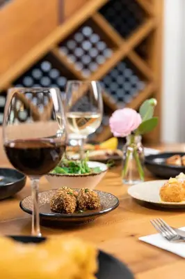 a wooden table with glasses of wine and food at The Inverkip Restaurant, Bar & Hotel in Inverkip