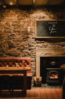 a restaurant with a table and a fireplace at The Inverkip Restaurant, Bar & Hotel in Inverkip