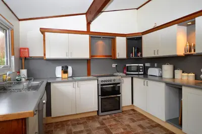 a kitchen with white cabinets and a stove top oven at Oystershell Lodge in Otter Ferry